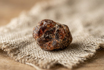 Makro surowego naturalnego kamienia z widocznymi inkluzjami na lnianej tkaninie