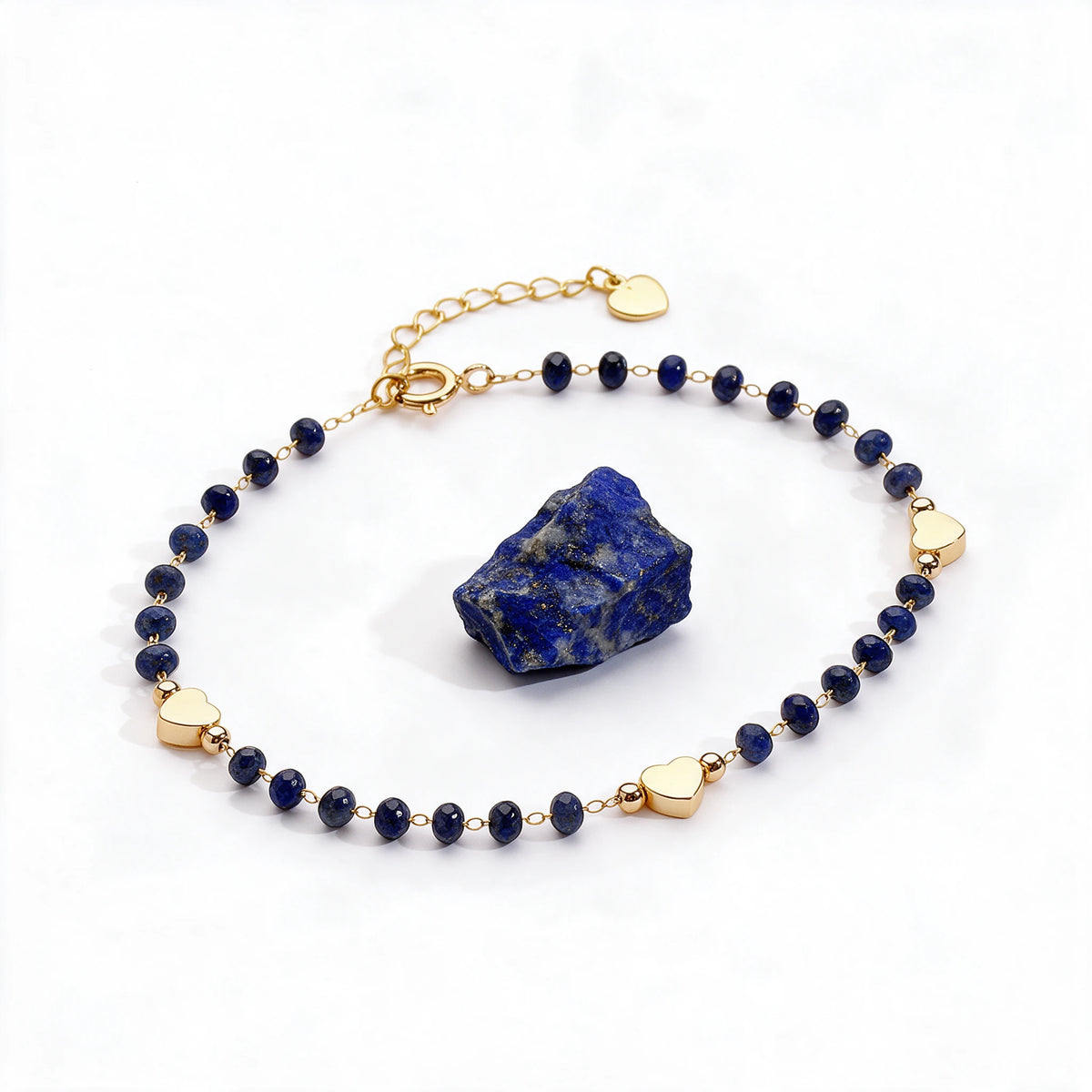 Bransoletka z lapis lazuli i serduszkami Coralie, obok osobnego minerału: lapis lazuli.