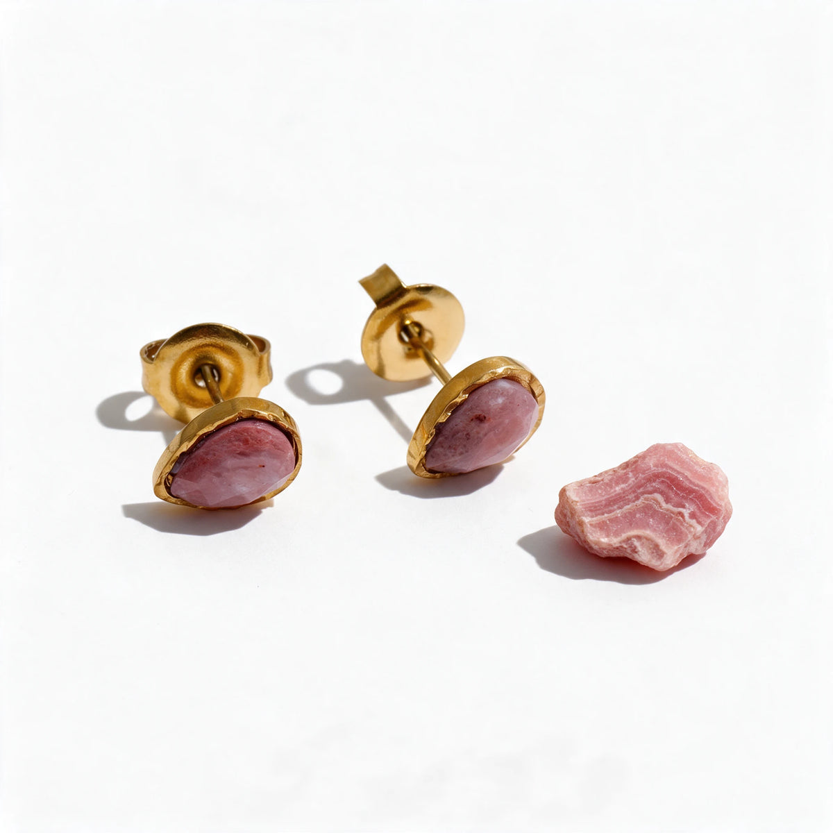 Kolczyki Thebe z rodochrozytem obok surowego rodochrozytu, minerał poza zestawem