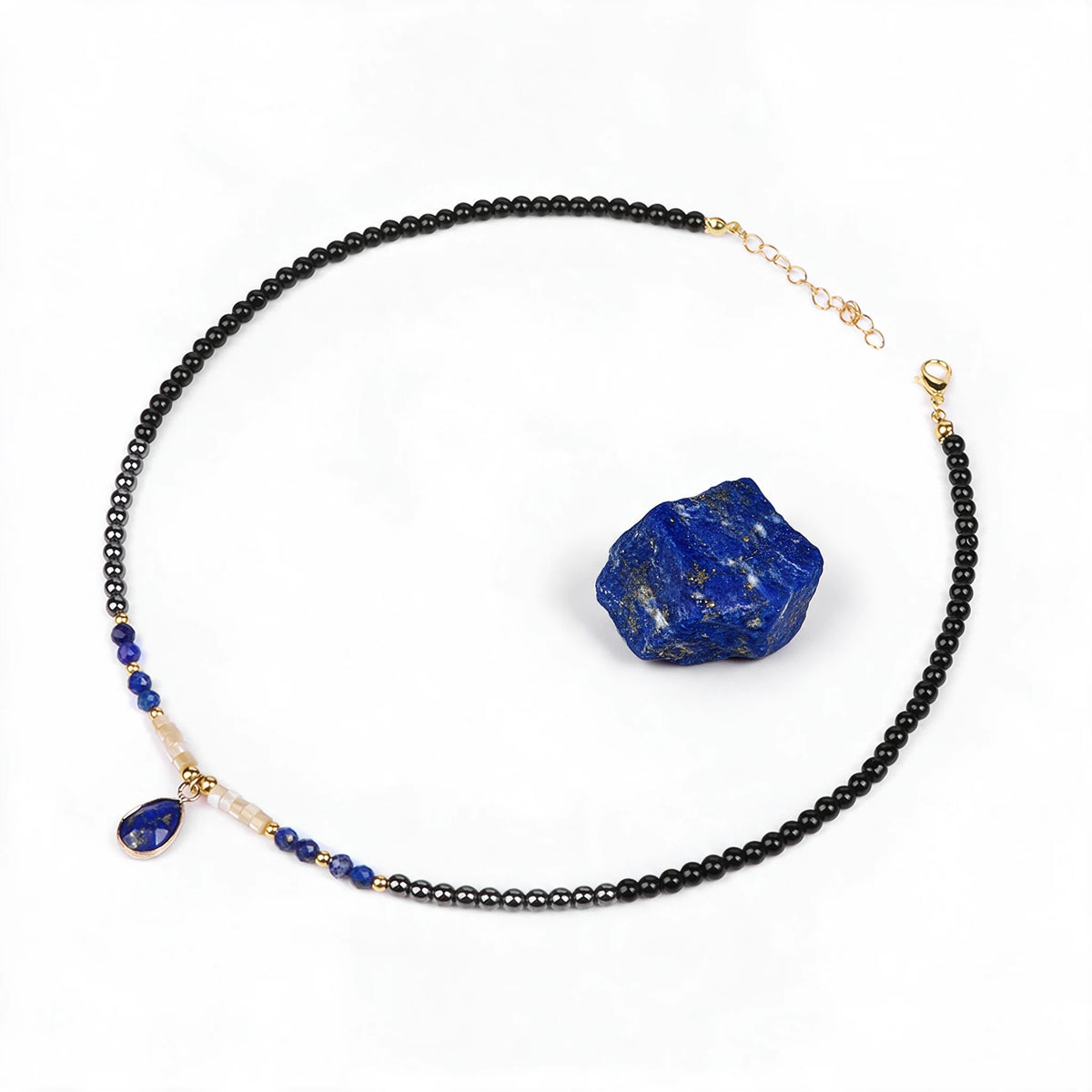 Naszyjnik Nashira z lapis lazuli obok surowego lapis lazuli, minerał poza zestawem