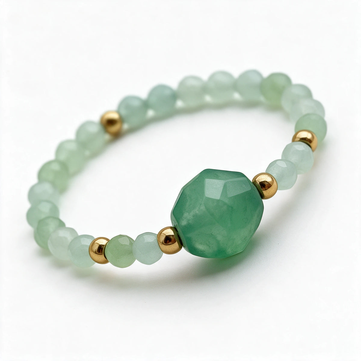 Zbliżenie większego koralika i złocistych detali pierścionka Nolia Awenturyn zielony.