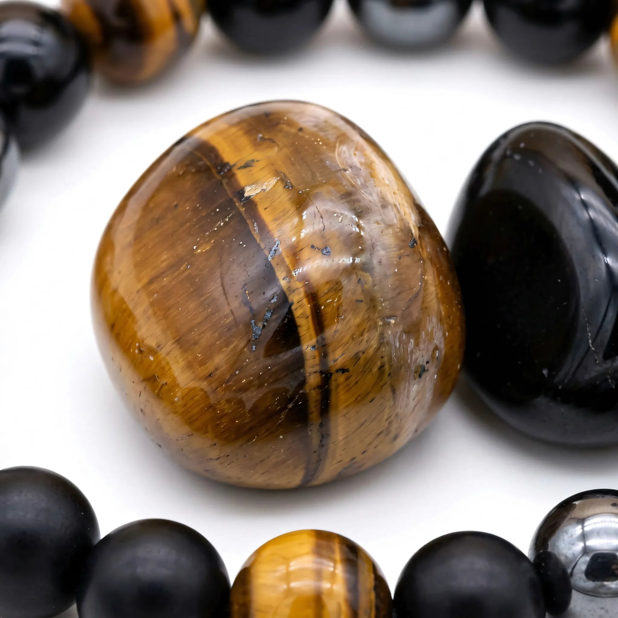 Bransoletka Argo: brązowe tygrysie oko, czarny obsydian i hematyt w zbliżeniu na polerowane kamienie naturalne
