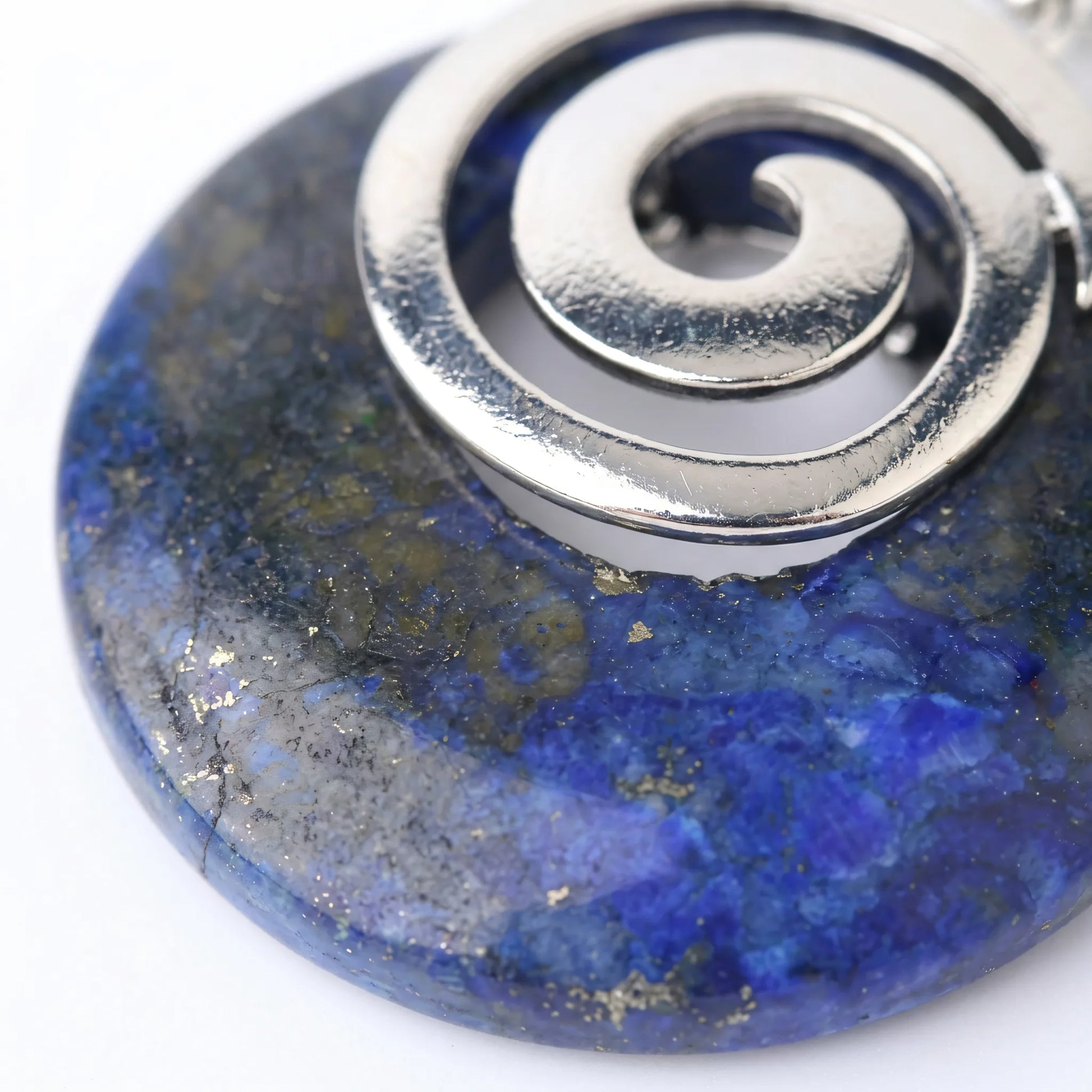 Naszyjnik z kamienia lapis lazuli Maia ze srebrną spiralą zbliżenie na niebieski minerał i złote drobiny pirytu