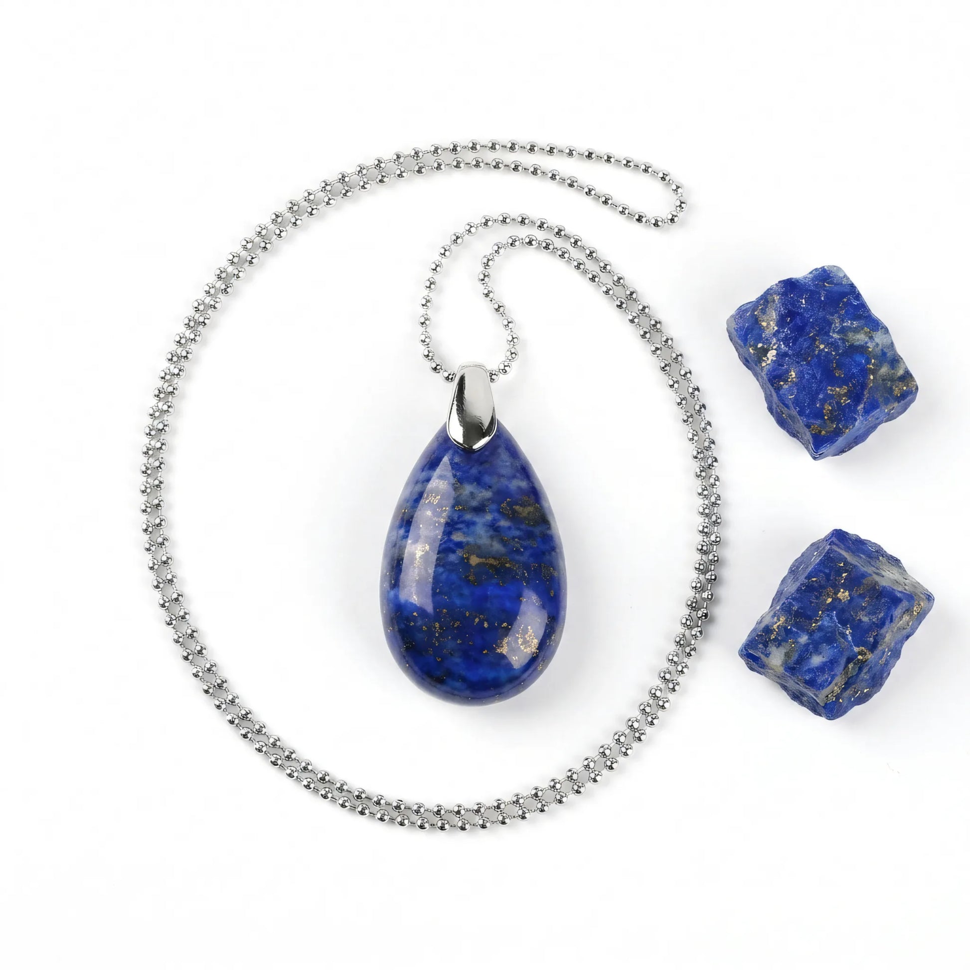 Naszyjnik z naturalnego kamienia lapis lazuli Vega w formie łezki na srebrnym łańcuszku kulkowym obok surowych bryłek